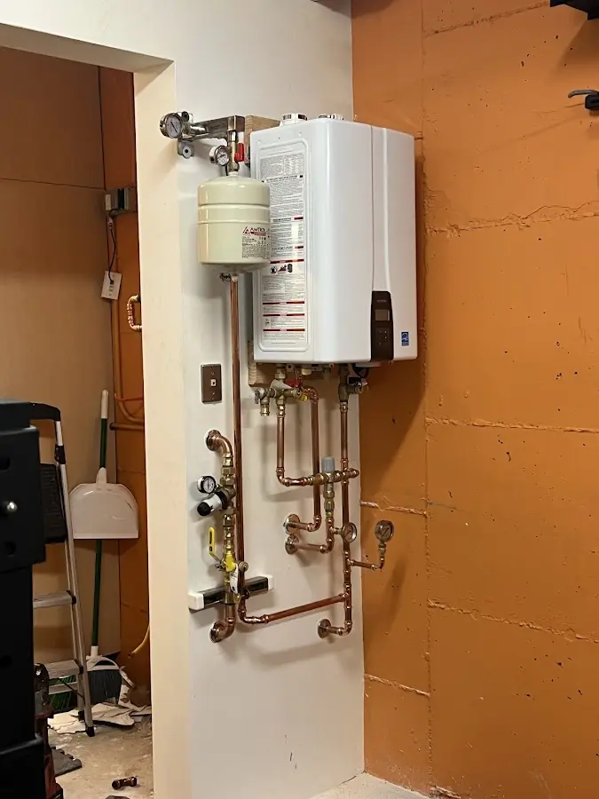 Plumbing technician inspecting water heater connections in Indiana